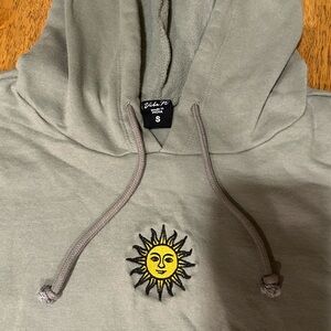 This is a olive green tj maxx hoodie with a cute sun patch.🌞